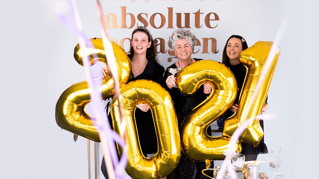 Foto von Maxine, Darcy und Margot Laceby, die goldene Luftballons halten mit den Zahlen 2021